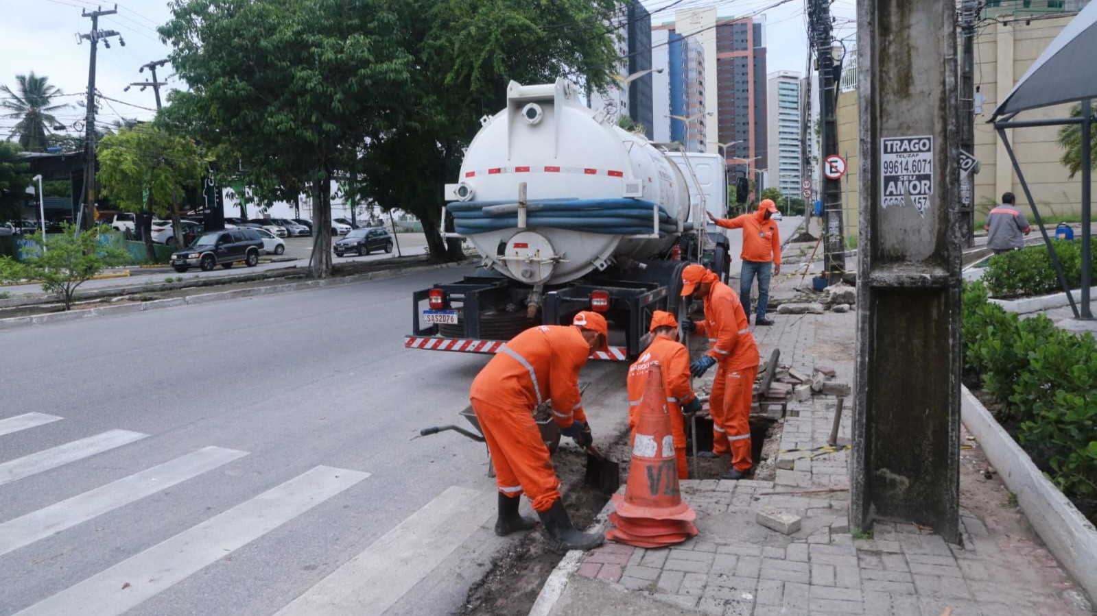 homens trabalhando na limpeza de uma boca de lobo